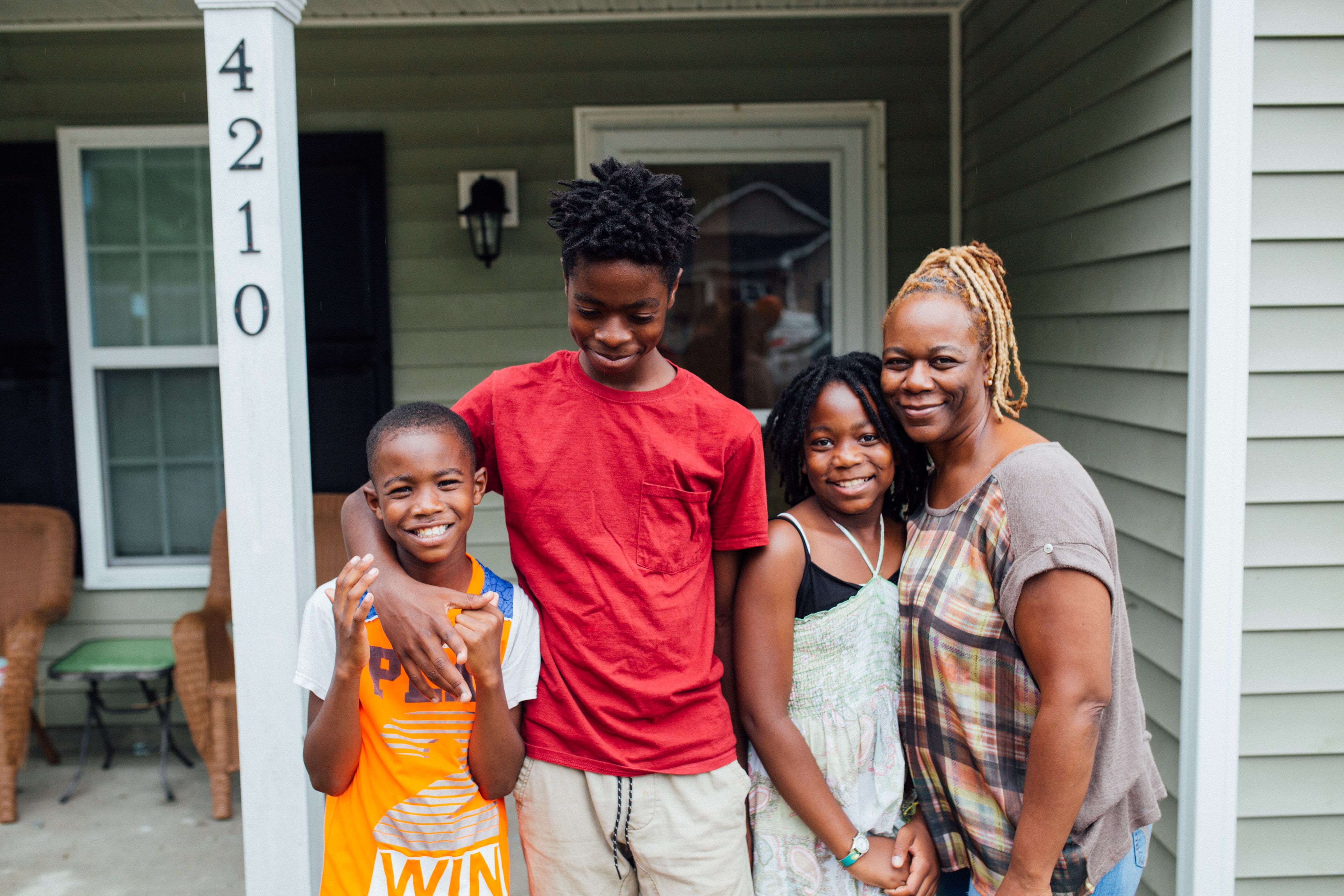 family standing in front of home