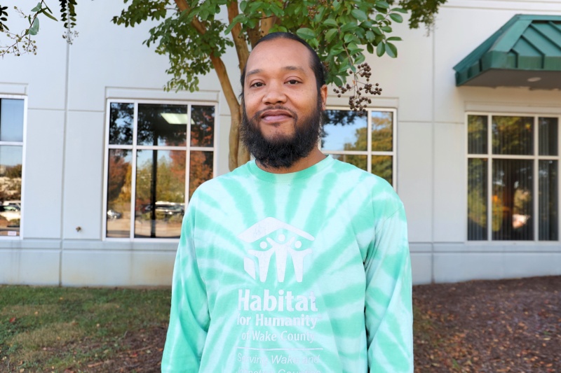 Staff member Chris Minor stands outside the Habitat Wake offices