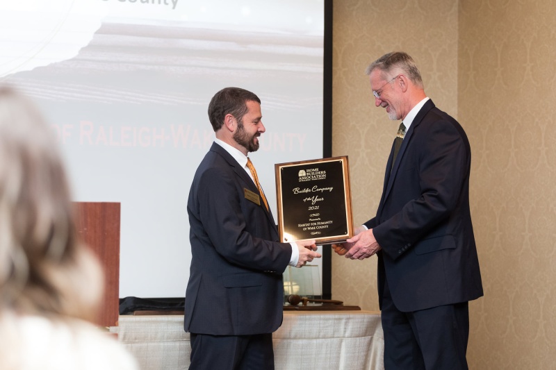 Habitat Wake receives builder of the year award from the HBA. CEO Bill Ahern is receiving a plaque from a representative.