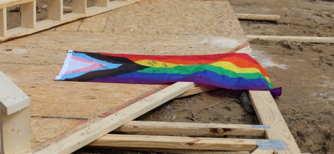 Volunteer signed pride flag nailed to roof truss