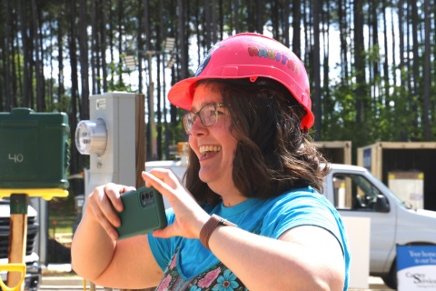 Mary Starke smiles and takes a photo of her home being built